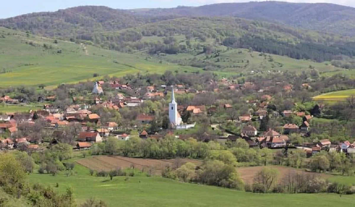 Imagine cu satul Crăciunel din Transilvania, ăn timpul verii. În imagine se distinge turnul alb al unei biserici
