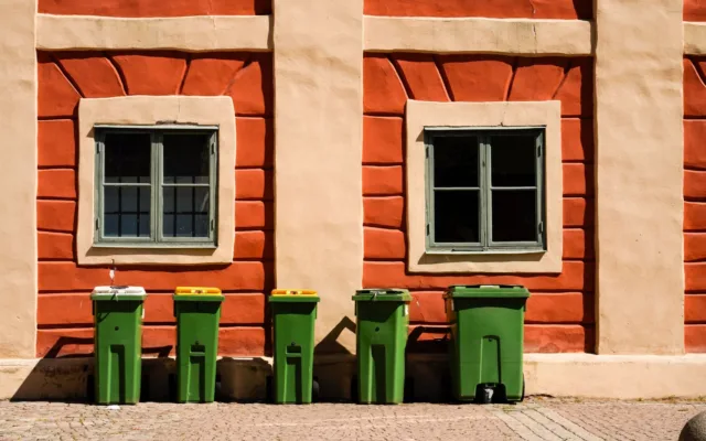 Containere pentru gunoi lângă clădire